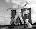 Landing Signal Officer Ensign R. J. Grant guiding in a F6F Hellcat fighter aboard USS Enterprise, 13 Mar 1945