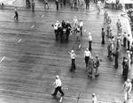 Wounded by aircraft gunfire, Aviation Ordnanceman Second Class Clifton R. Bassett of VB-3 was carried down the flight deck of Enterprise, 4 Jun 1942, photo 1 of 2