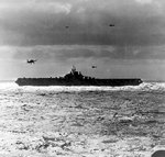 USS Hancock recovering aircraft in the South China Sea, Jan 1945; note three F6F Hellcat and one TBM Avenger aircraft in flight; seen from USS New Jersey