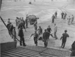 US Navy LST-134 and LST-325 beached at Normandy, France as jeeps driving along the invasion beach carry casualties to the waiting vessels, 12 Jun 1944, photo 4 of 4