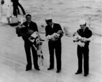 USS Oklahoma crewmen Lloyd Payne (left), Chief Petty Officer Fuchs (center), and Slajus (right) with refugee children, Bilbao, Spain, Aug 1936