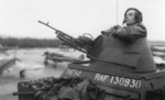 Leslie Bassett of No. 2777 Field Squadron RAF Regiment at the turret of his Humber Light Reconnaissance Car, the Netherlands, 1944-1945; note Typhoon aircraft of No. 257 Squadron RAF in background