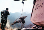 American helicopter lowering M101 105mm howitzer during the construction of a mountin-top fire base in Vietnam, 1 Jun 1968; the Marine in foreground was with US 3rd Marine Division