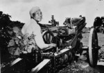 A Chinese soldier posing next to a M1A1 75-mm Pack Howitzer atop M1 carriage, circa 1942