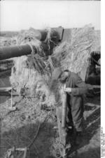 German soldier preparing a shell for an 8.8 cm FlaK gun, Russia, 1942, photo 1 of 2