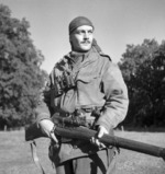 Canadian Calgary Highlanders Sniping Platoon Sergeant Harold A. Marshall posing with his Lee-Enfield No. 4 Mk. I rifle, Kapellen, Belgium, 6 Oct 1944