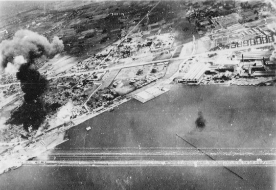 Oil storage tanks burning during US Navy carrier aircraft attack, Takao (now Kaohsiung) harbor, Taiwan, 12 Oct 1944