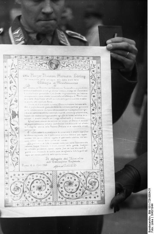 German soldier displaying a certification made to German 1st Paratroop Panzer Division 'Hermann Göring' to transfer artwork from Monte Cassino, Italy to Germany, 4 Jan 1944