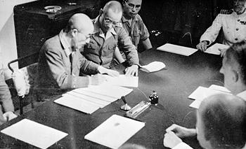 General Seishiro Itagaki signing surrender documents aboard HMS Sussex at Singapore, 4 Sep 1945