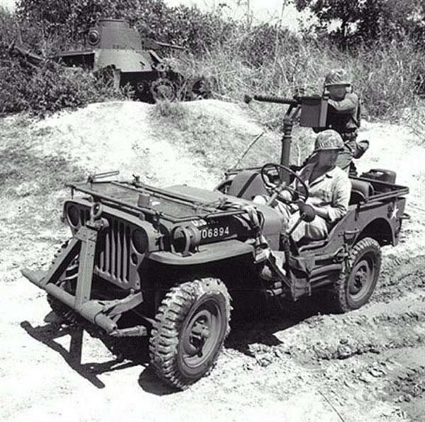 Post-war re-enactment of a Jeep mounted with a Browning M1919 machine gun; note hulk of Japanese Type 95 Ha-Go light tank.