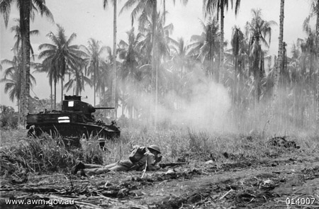 Australian Company Sergeant Major McCominski and Private M. Daniels waited as the accompanying M3 General Stuart tank attacking a Japanese pillbox, near Buna, New Guinea, 2 Jan 1943