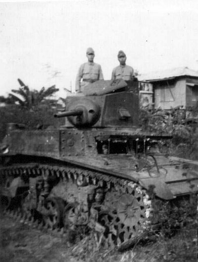 Three Japanese soldiers posing with a captured American M3 light tank, near Manila, Philippine Islands, Jan 1942; note the face of one Japanese soldier showing through the driver's window