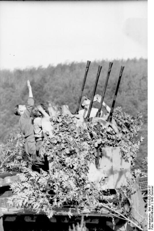 Camouflaged German 2 cm Flakvierling 38 anti-aircraft gun mounted atop a SdKfz. 7 half-track vehicle, immediately prior to Battle of Kursk, summer 1943, photo 1 of 2