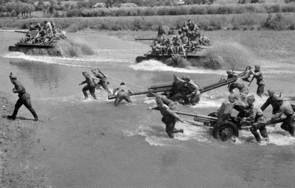 Soviet troops and heavy equipment fording a shallow river in Ukraine, 1944; note T-34 tanks, ZiS-3 gun, and M-42 gun