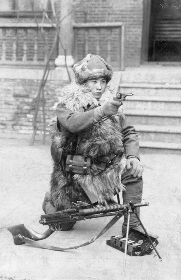 Japanese Army soldier posing with a Type 26 revolver and a Type 11 machine gun, circa 1940s