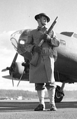 A security guard with a Winchester Model 1912 shotgun at Boeing Seattle Plant, Washington, United States, Dec 1942